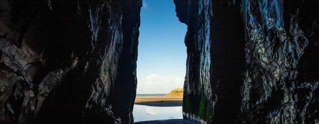 Tall cave exit opening to sea
