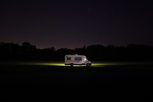 distant night shot of RV glowing with green light